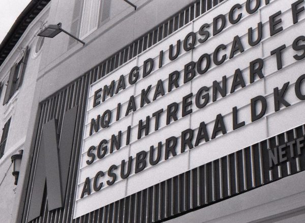 Monochrome building with a netflix sign and scrambled letters.